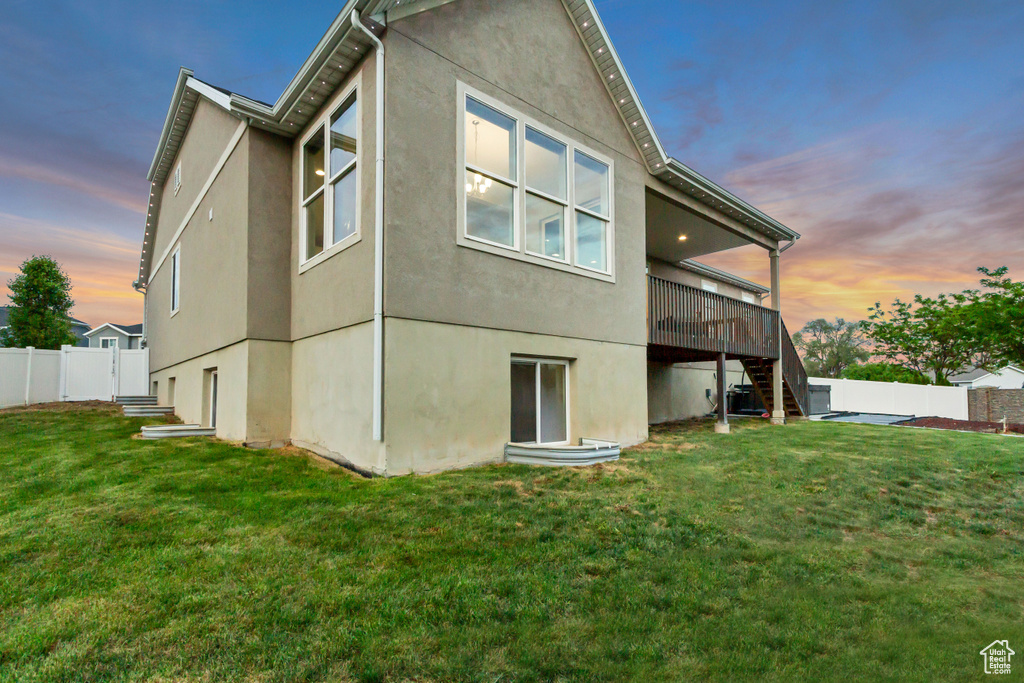 Back of property with stairway, stucco siding, and a deck