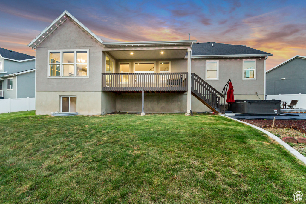 Rear view of house with stucco siding, stairs, and a deck
