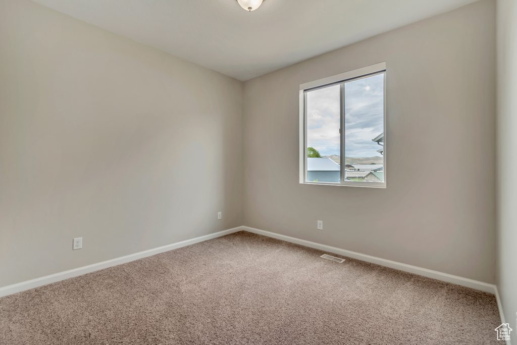 Spare room with carpet and baseboards