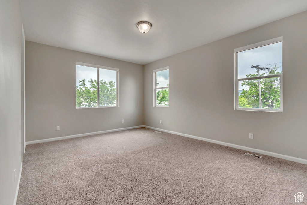 Spare room featuring light carpet and baseboards