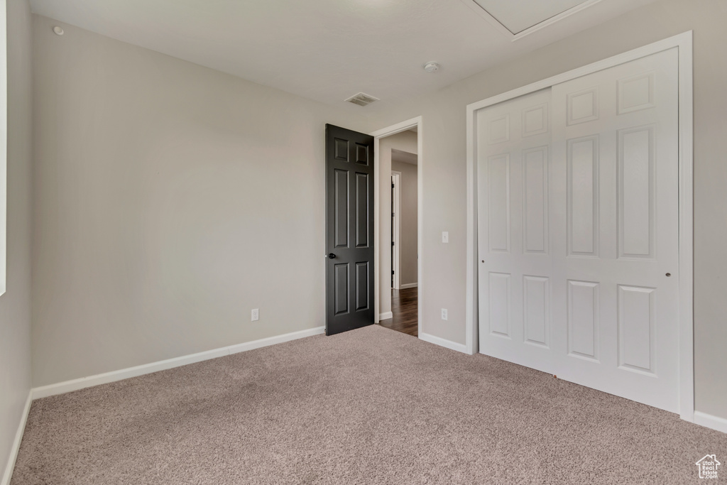Unfurnished bedroom with carpet floors, baseboards, and a closet