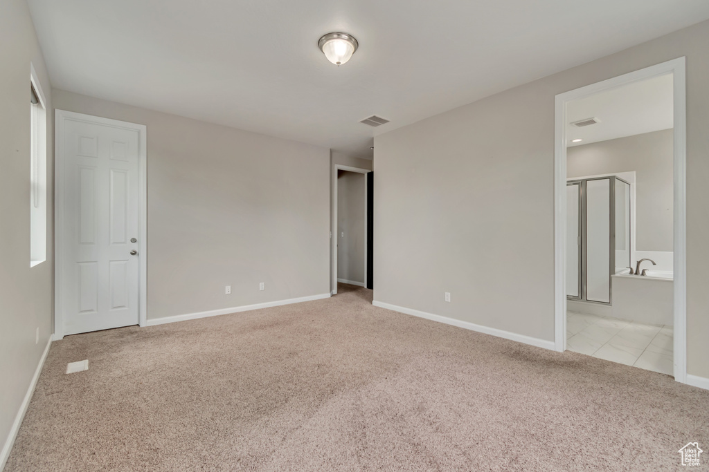 Unfurnished bedroom featuring carpet floors, baseboards, and connected bathroom
