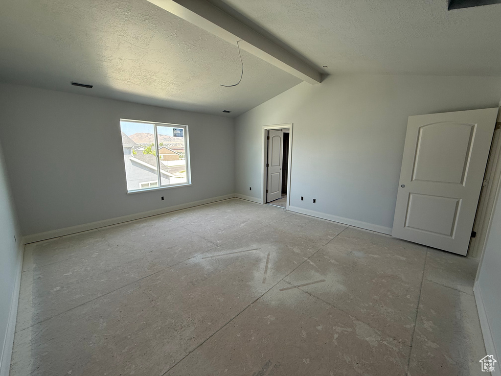 Empty room with a textured ceiling and baseboards