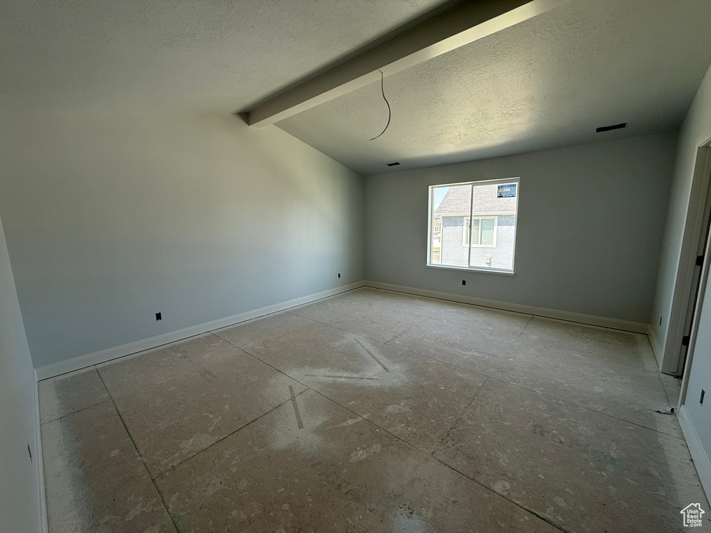 Empty room with baseboards and a textured ceiling