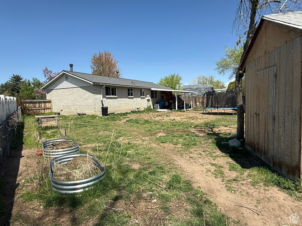 View of yard featuring a trampoline and fence