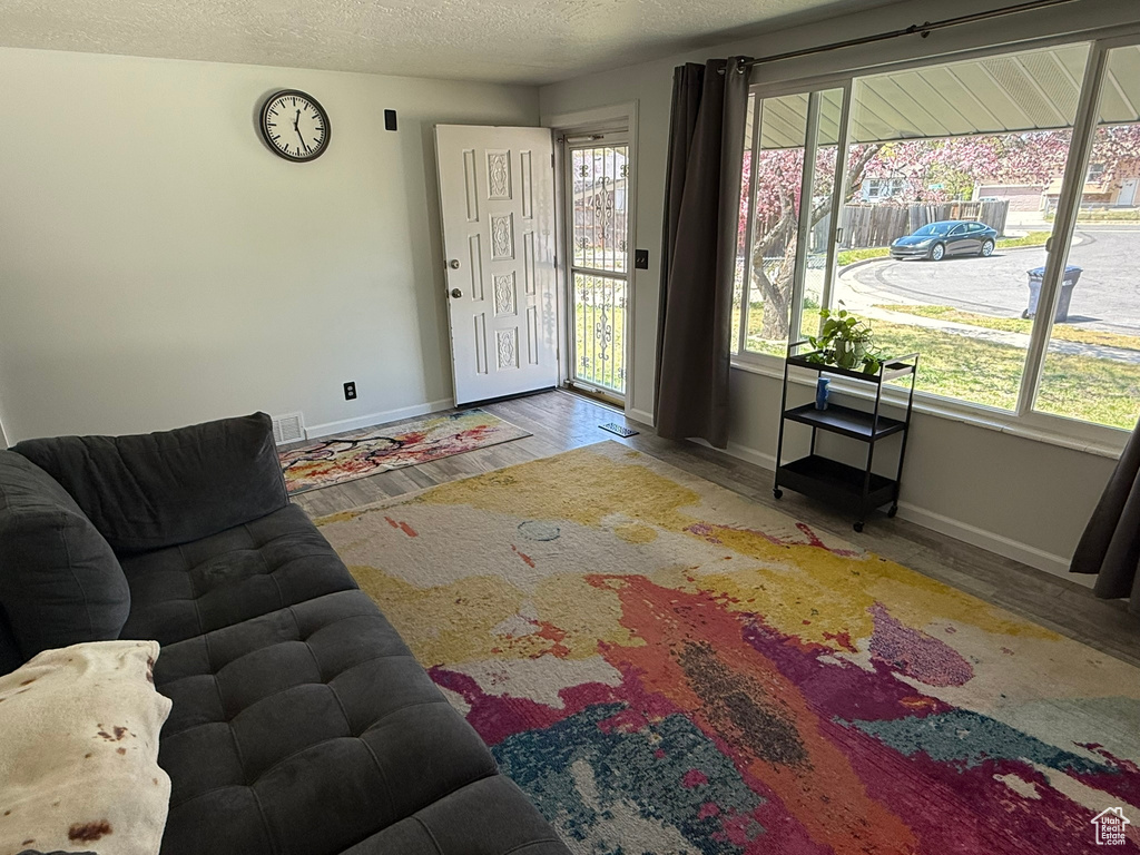 Living room featuring wood finished floors, baseboards, and a textured ceiling