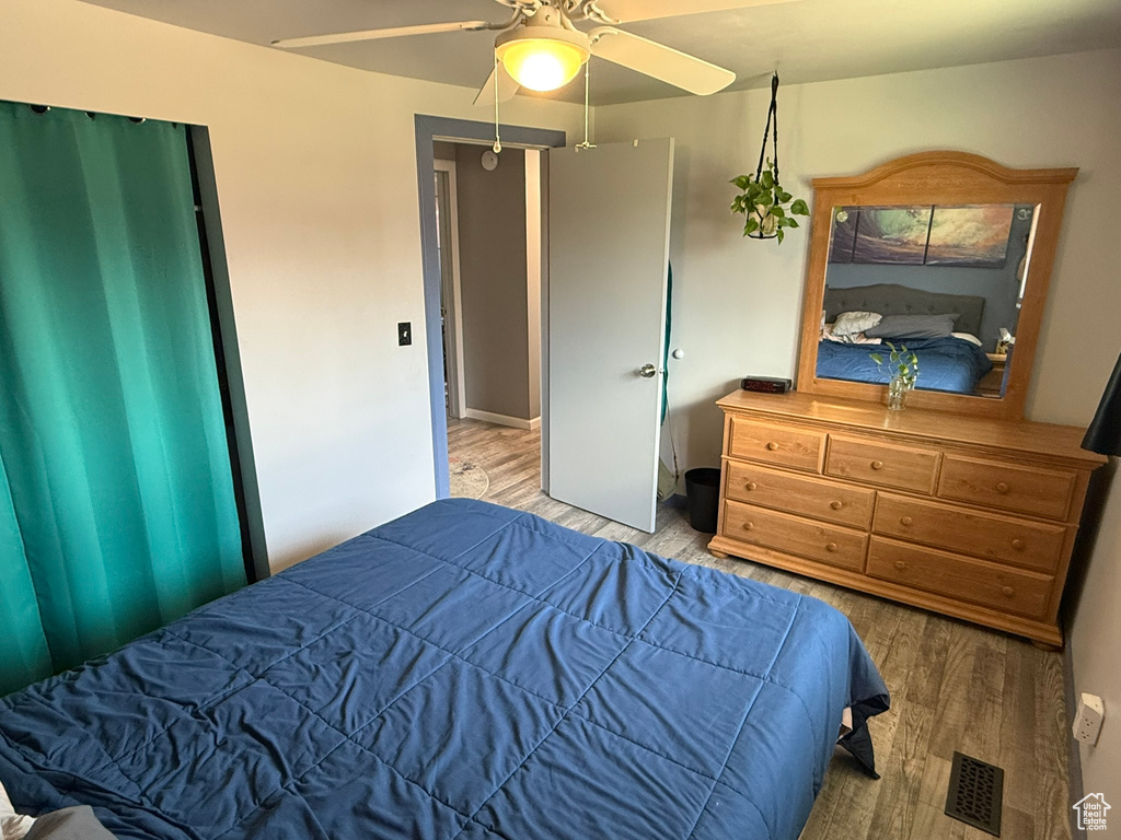 Bedroom with wood finished floors, visible vents, and ceiling fan