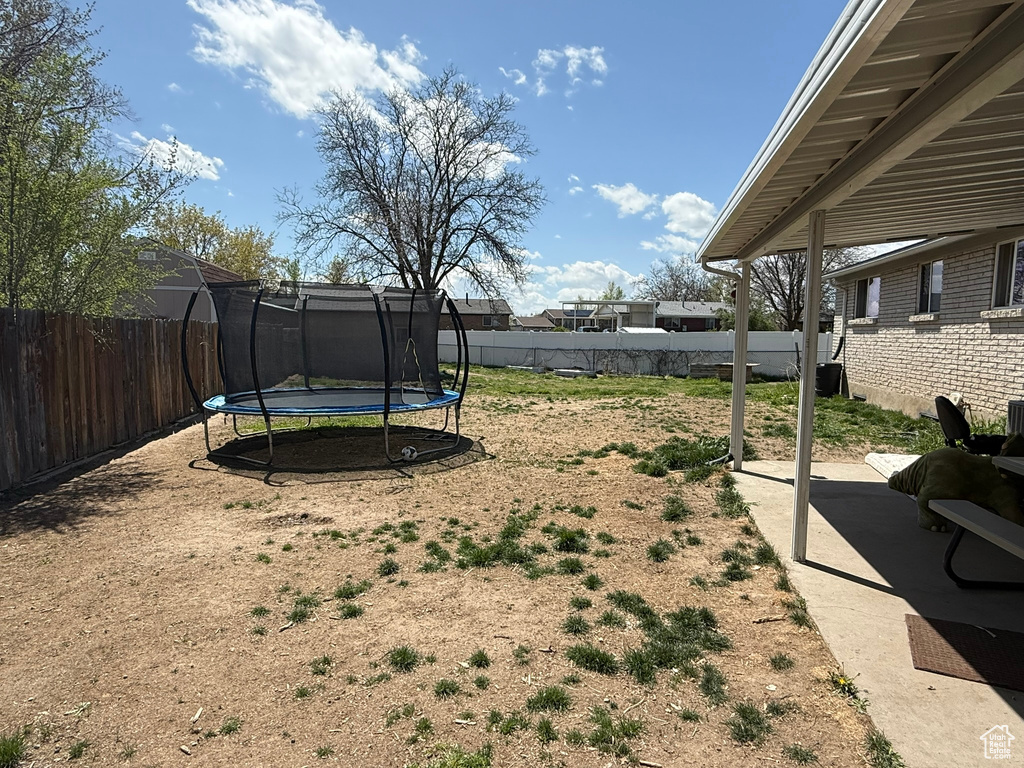 View of yard featuring a fenced backyard and a trampoline