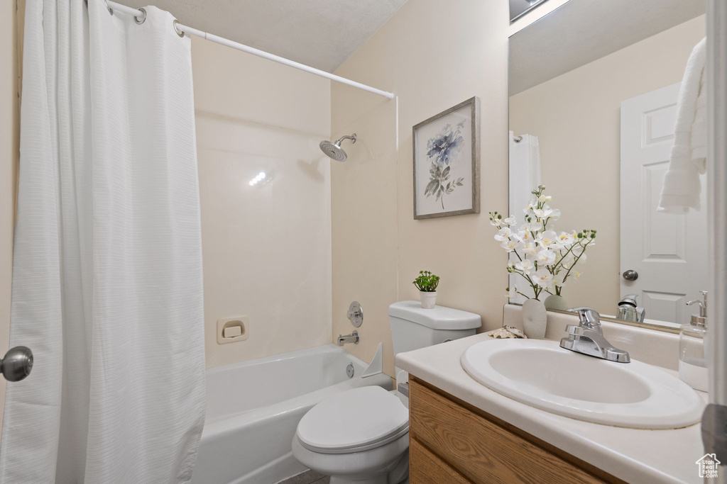 Bathroom with shower / tub combo, toilet, and vanity