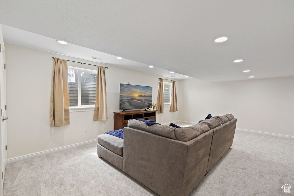 Living room with recessed lighting, visible vents, baseboards, and light carpet