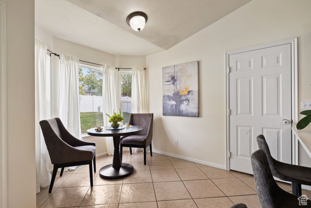 Sitting room featuring vaulted ceiling, baseboards, and light tile patterned floors