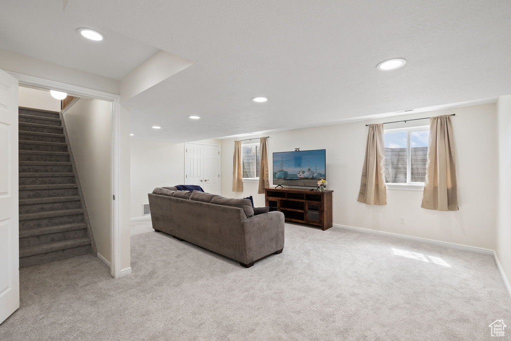 Living area with baseboards, carpet, recessed lighting, and stairway