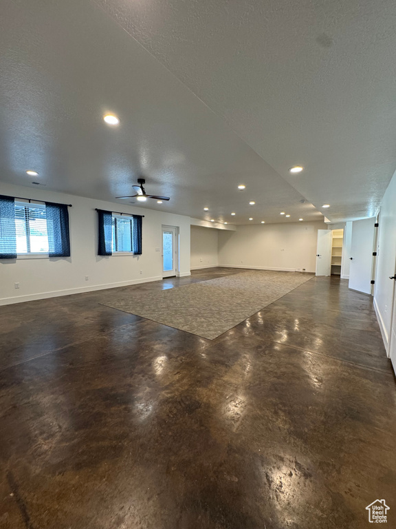 Spare room featuring concrete floors, recessed lighting, baseboards, a textured ceiling, and a ceiling fan