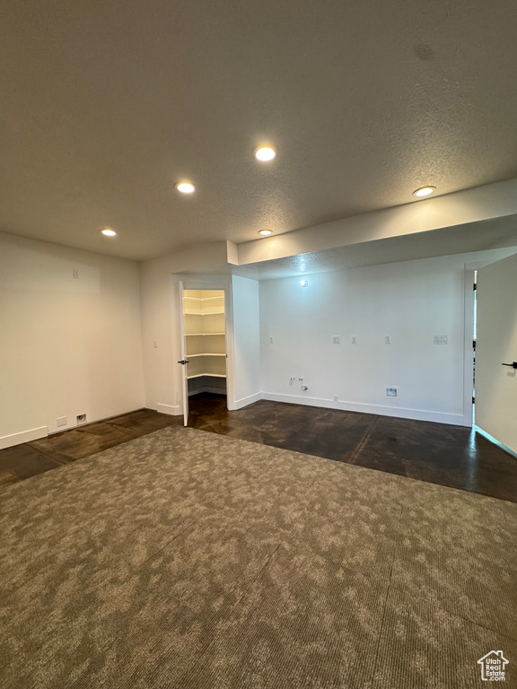 Finished below grade area with recessed lighting, dark carpet, and baseboards