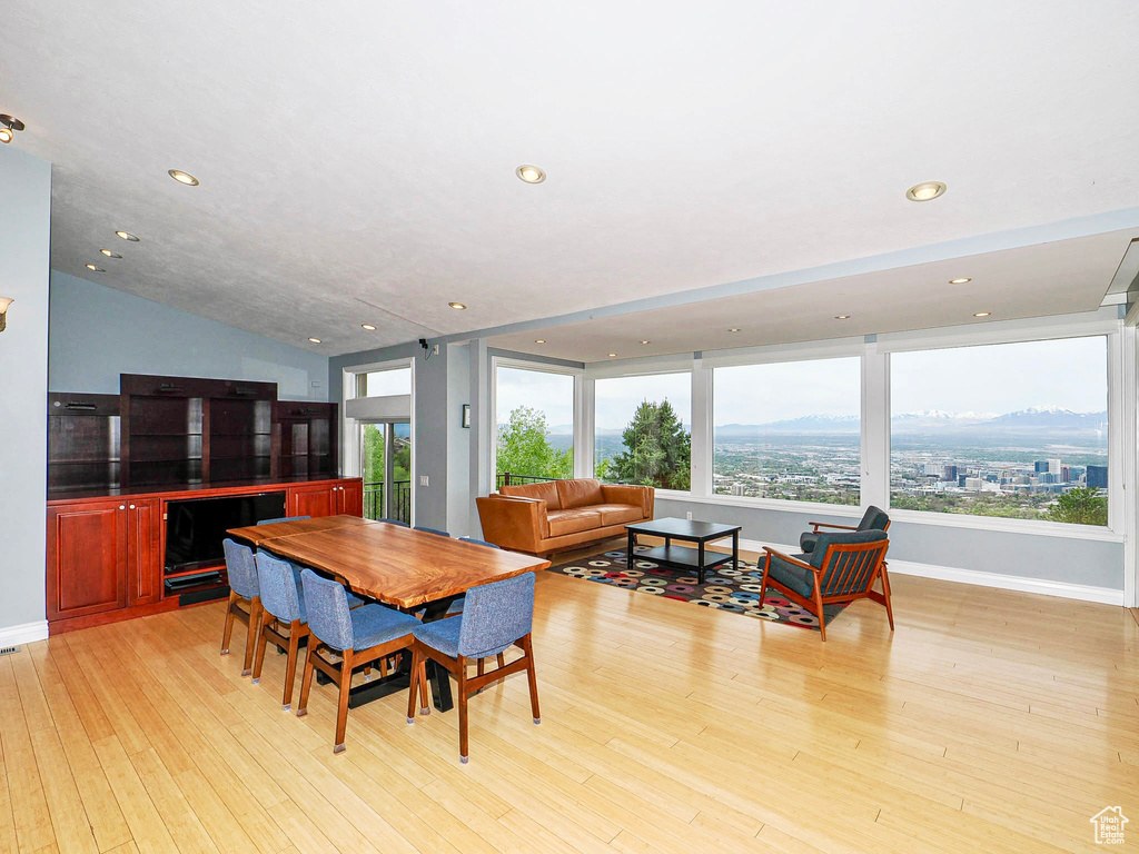 Dining area with light wood-style flooring, recessed lighting, baseboards, and vaulted ceiling