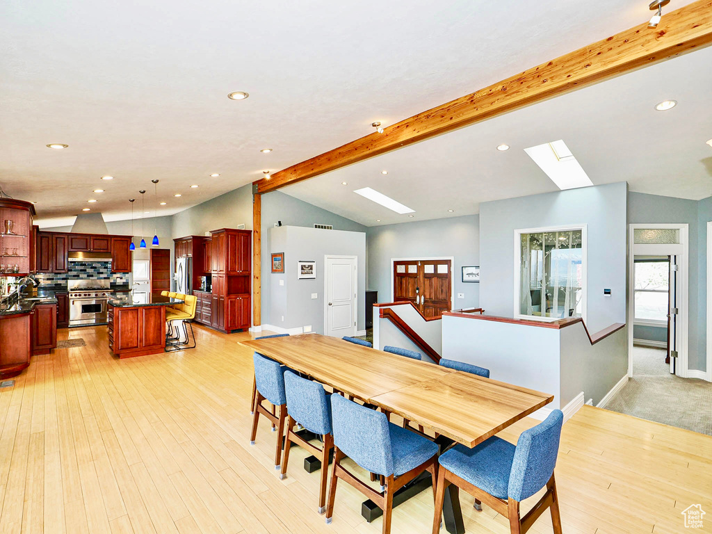 Dining room with a skylight, recessed lighting, light wood-style floors, and baseboards
