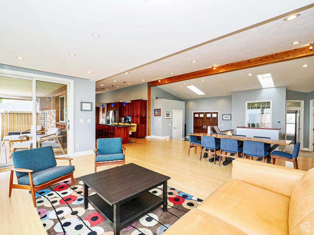 Living room with recessed lighting, baseboards, light wood-type flooring, and a skylight