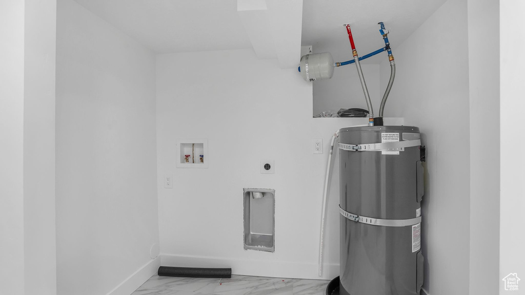 Clothes washing area with baseboards, secured water heater, washer hookup, marble finish floor, and laundry area