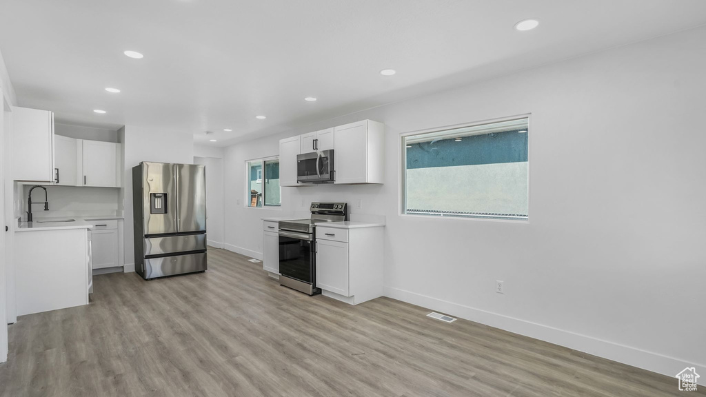 Kitchen featuring stainless steel appliances, baseboards, visible vents, and a sink
