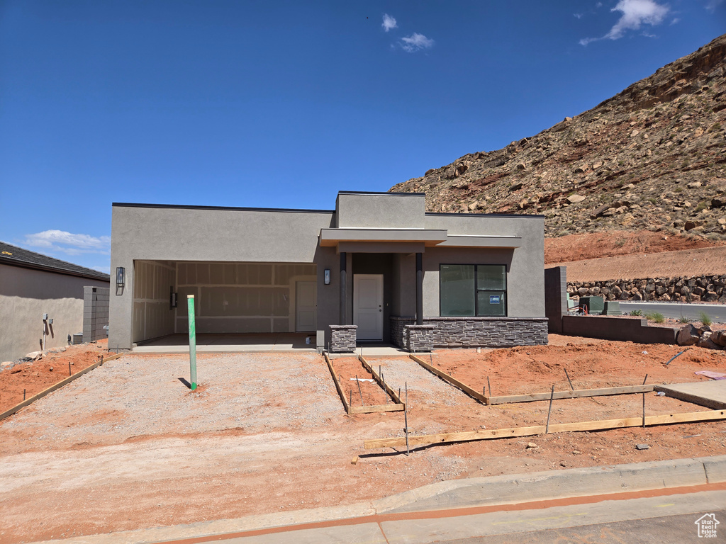 Contemporary house with fence, stucco siding, and stone siding