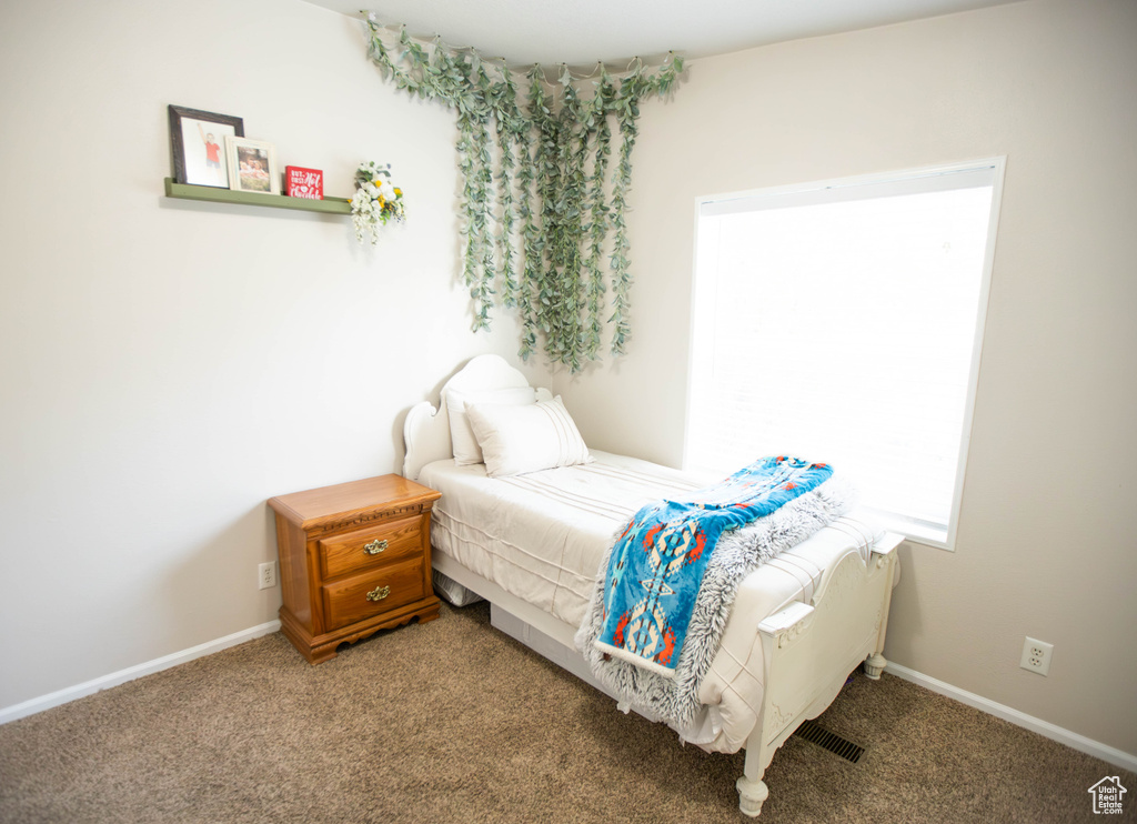 Carpeted bedroom with visible vents and baseboards