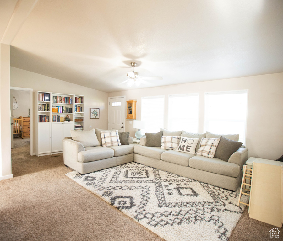 Carpeted living area featuring lofted ceiling and ceiling fan