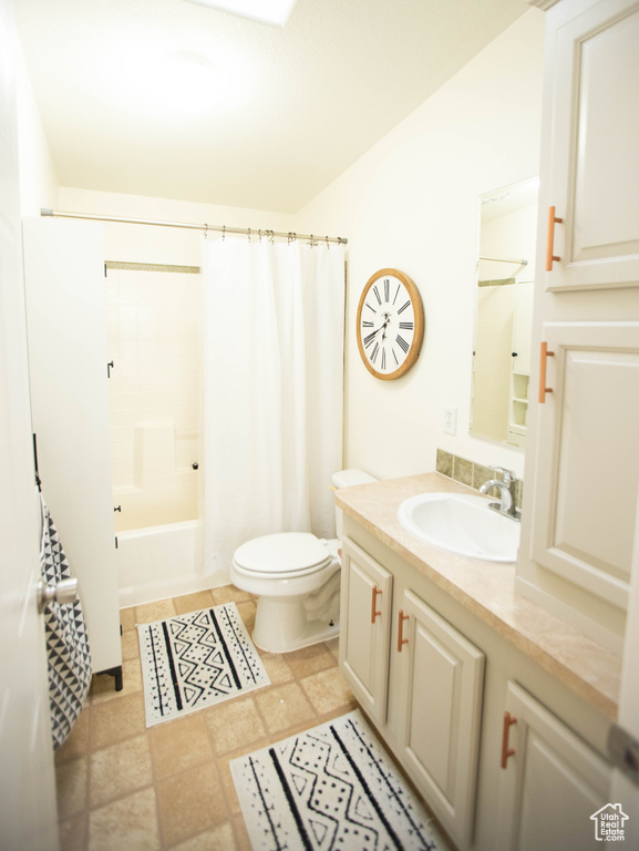 Bathroom with toilet, vanity, and shower / tub combo with curtain