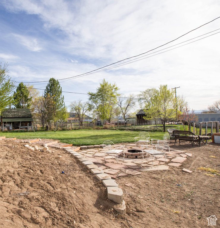 View of yard featuring fence, a patio area, and an outdoor fire pit