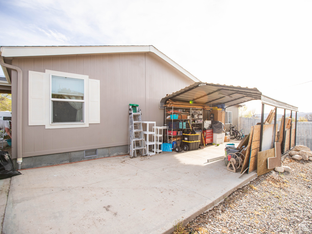 View of side of home featuring fence and crawl space