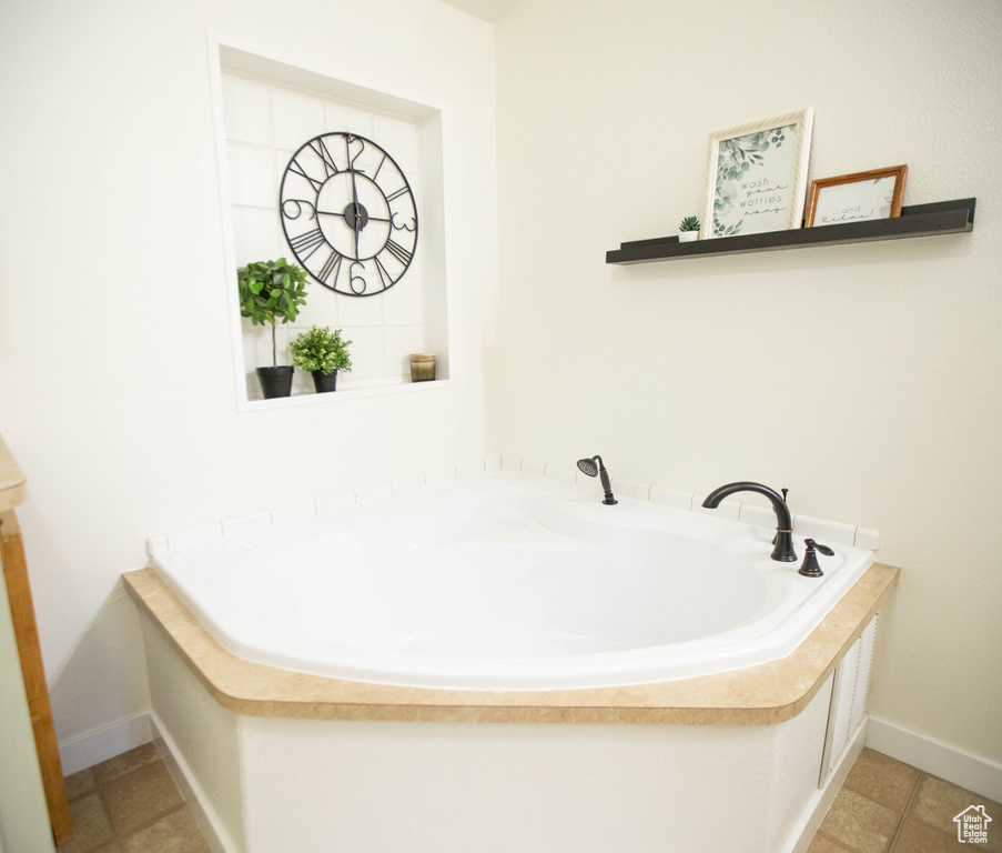 Bathroom with a bath and baseboards