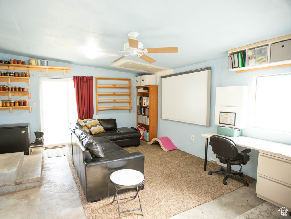 Interior space with lofted ceiling, a ceiling fan, and built in desk