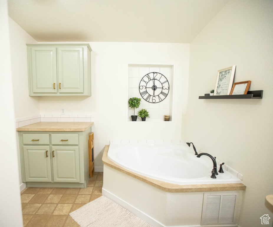 Full bathroom with baseboards, a bath, visible vents, and vanity