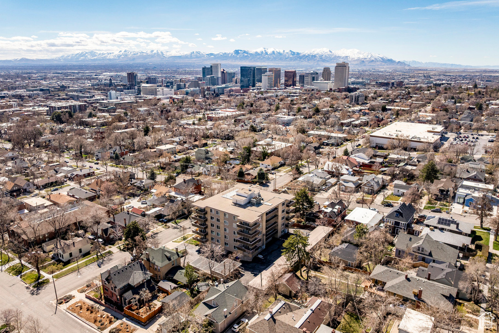 Aerial view of property and surrounding area with a mountainous background and nearby urban area