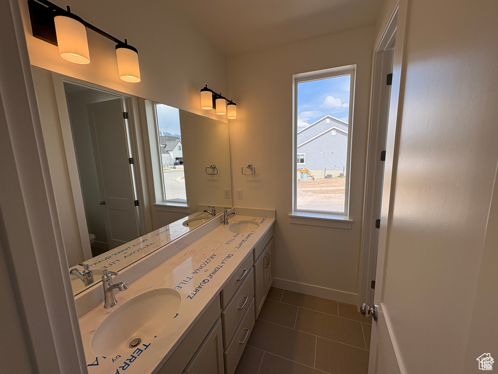 Bathroom featuring a wealth of natural light, a sink, and toilet