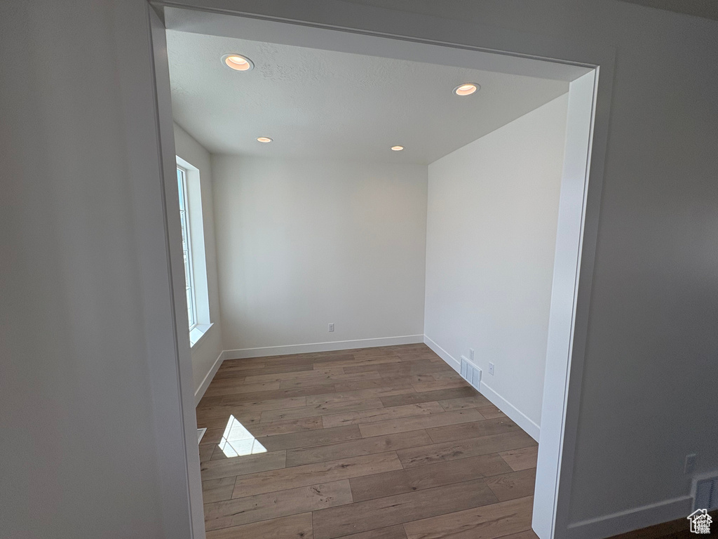 Empty room with visible vents, wood finished floors, and recessed lighting