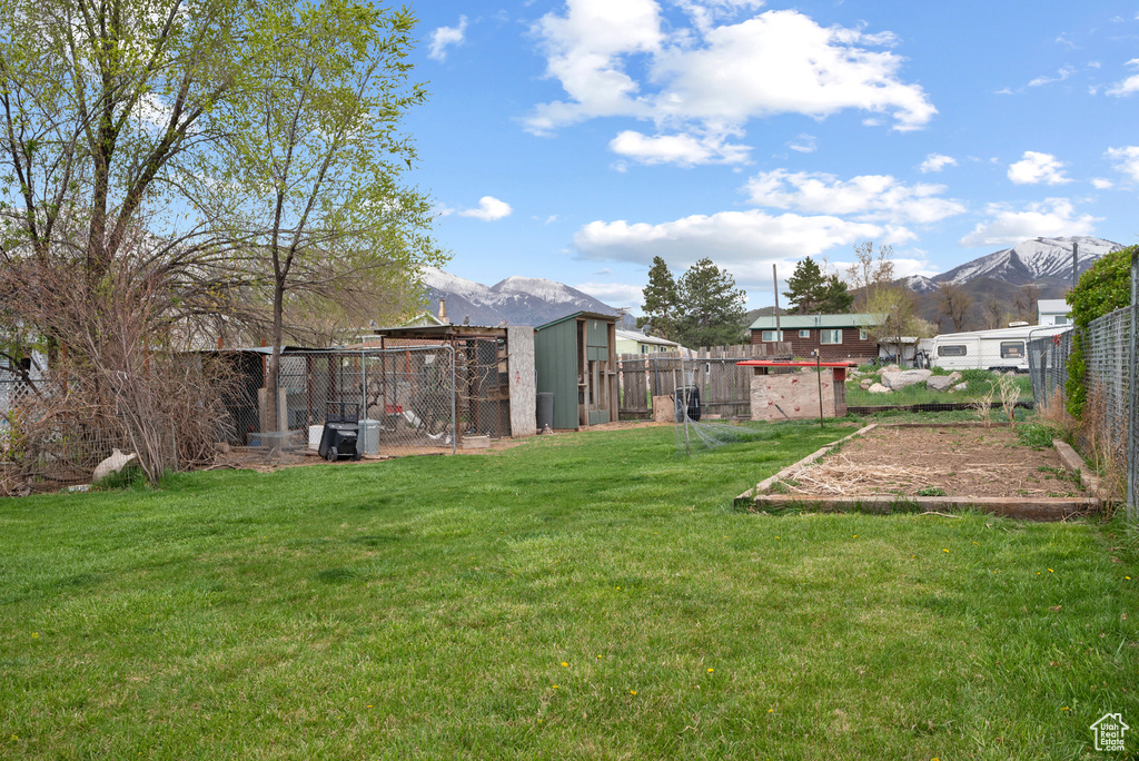View of yard featuring a fenced backyard, a mountain view, and exterior structure