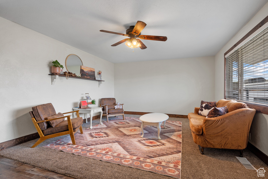 Living area featuring visible vents, baseboards, and ceiling fan