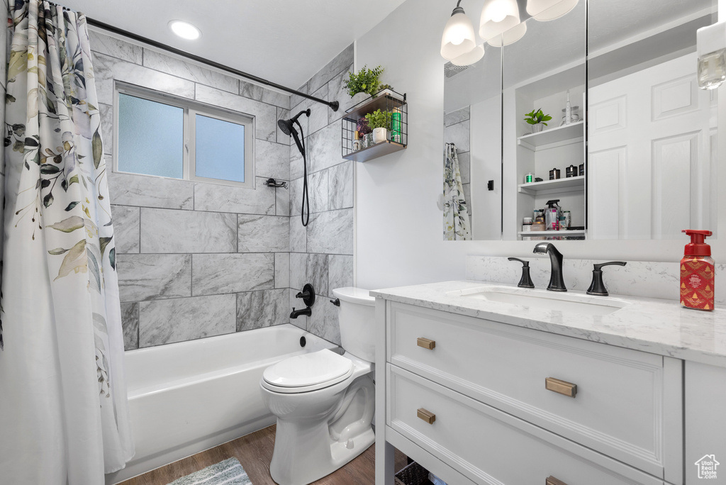 Full bath with wood finished floors, toilet, vanity, and shower / bath combination with curtain