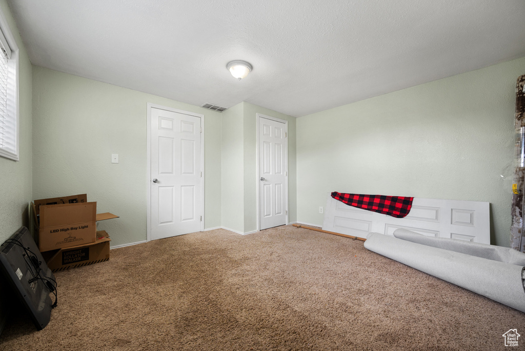 Unfurnished room featuring carpet, visible vents, and baseboards