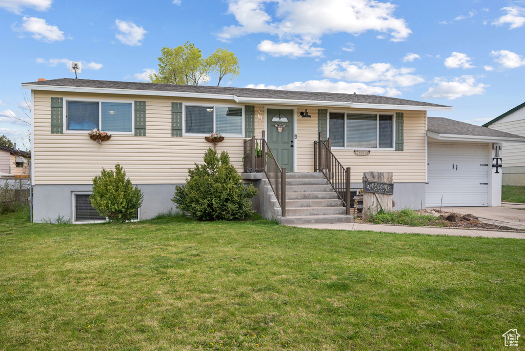 View of front of property featuring an attached garage, a front lawn, and concrete driveway