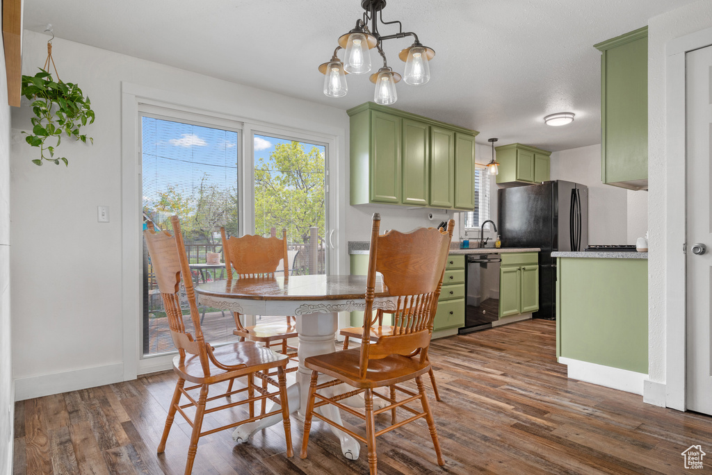 Dining room featuring baseboards, a chandelier, and dark wood-type flooring