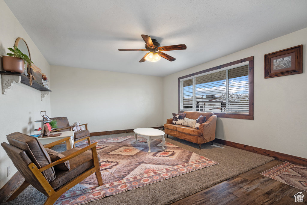 Living area with baseboards, a ceiling fan, and wood finished floors