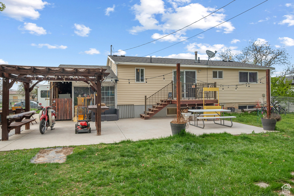 Back of property featuring fence, a pergola, a yard, and a patio