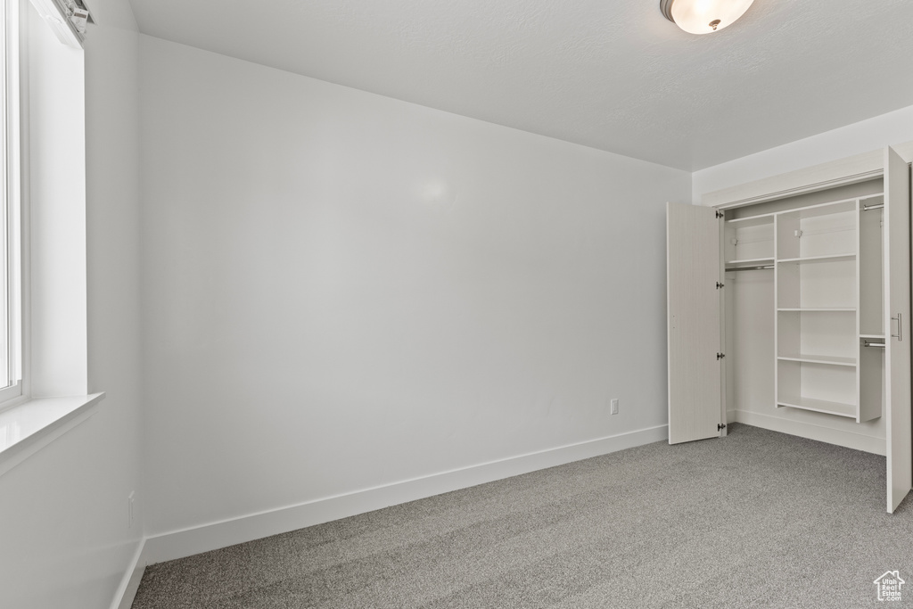 Unfurnished bedroom with a closet, carpet flooring, and baseboards