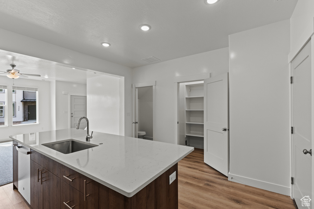 Kitchen featuring light wood finished floors, dishwasher, a sink, and ceiling fan