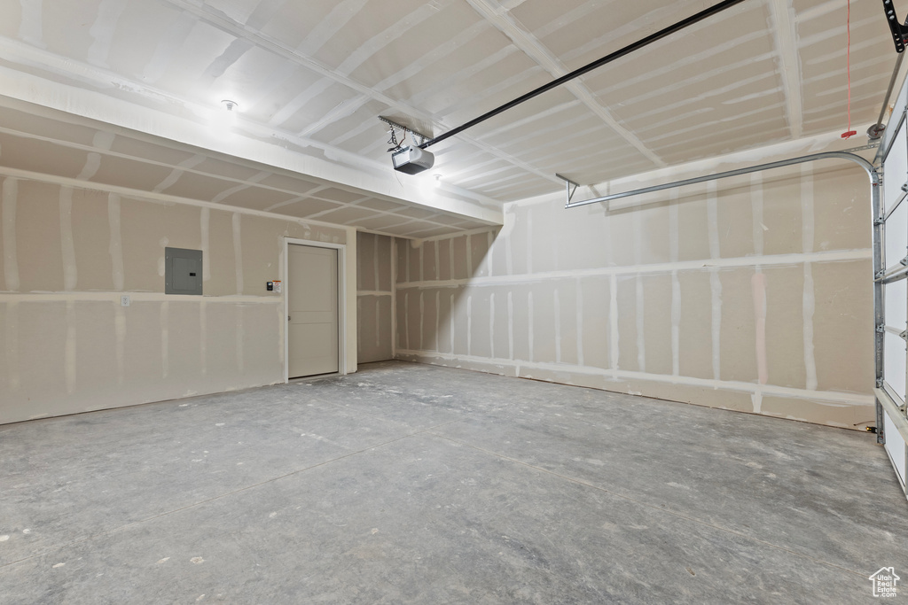 Garage featuring electric panel and a garage door opener