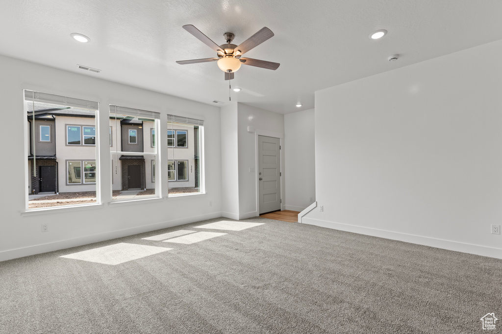 Carpeted spare room with ceiling fan, baseboards, visible vents, and recessed lighting