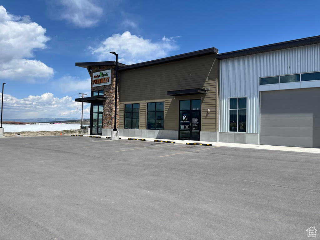 View of building exterior featuring uncovered parking and a water view