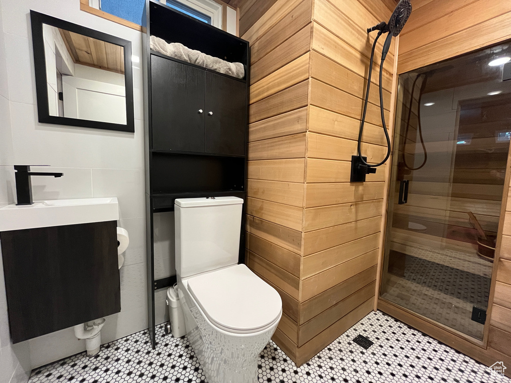 Full bath with a shower stall, toilet, vanity, and wood walls