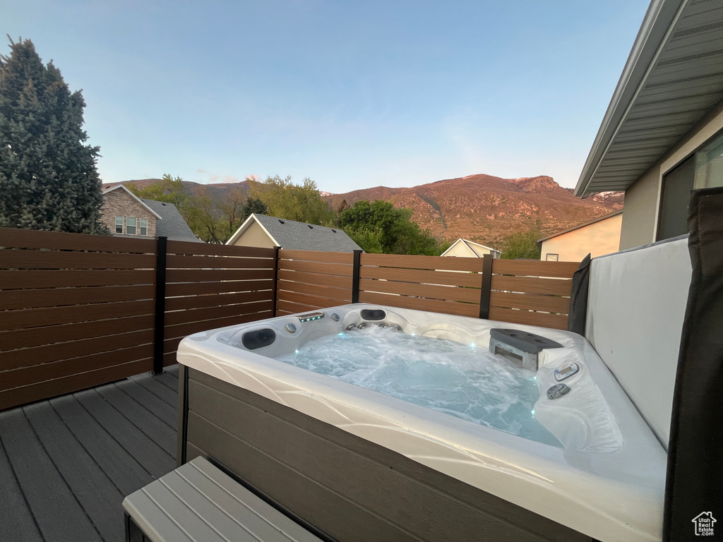 Deck with a hot tub and a mountain view
